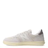 Championes urbanos New Balance modelo Court, color beige con detalles en crema y suela de goma con efecto envejecido. Presentan el logo N característico en los laterales y perforaciones en la puntera para mayor ventilación.