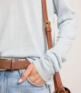 Suéter de punto color celeste, con cuello redondo y mangas largas.