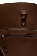 Bolso shopper marrón con acabado cepillado suave, asas ajustables de cuero con hebilla metálica, cierre de mosquetón y compartimento interior con cierre.