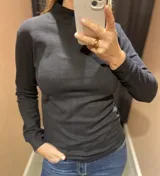 Polera de cuello alto y manga larga, confeccionada en tejido de algodón liso, con ajuste al cuerpo.