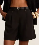 Short color visón de corte sastrero, tiro alto, con pliegues delanteros, trabillas y cinturón fino de cuero sintético.