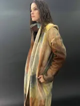 Tapado largo gris de lana merino con bolsillos laterales y corte particular en los hombros.