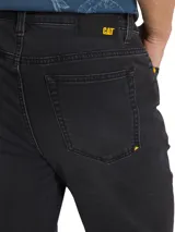 Pantalón de jean negro de corte slim fit, con cierre de cremallera y botón metálico. Diseño de cinco bolsillos, remaches con logo CAT y parche de cuero con logo en la parte trasera de la cintura.