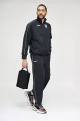 Bolso botinero negro con cierre superior y cinta de agarre.