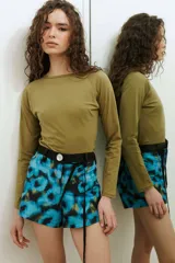 Short de tafeta negro de tiro alto, con botón de nácar y cinturón verde incorporado con tiras largas para atar.