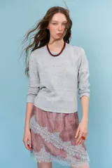 Falda tubo corta de color marrón con estampado de lunares blancos, detalle de encaje blanco en el dobladillo y tiras decorativas.