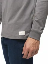 Remera de manga larga con cuello redondo, confeccionada en algodón, de corte clásico y diseño minimalista con detalle de etiqueta pequeña en el ruedo.