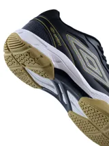 Championes Umbro Grip Pad para hombre, diseñados para deportes de cancha como pádel. Presentan un diseño en color negro con detalles en dorado, entresuela blanca y suela de goma color caramelo para mayor tracción.