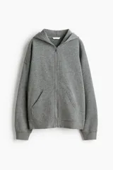 Campera de felpa gris melange con cierre frontal, capucha y bolsillos delanteros tipo canguro, de corte holgado y hombros caídos.