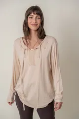 Remera color beige de manga larga con aplique de encaje en el escote y lazo ajustable.