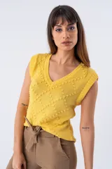 Chaleco de punto amarillo con cuello en V y diseño calado.