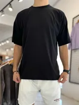 Remera oversize negra lisa, de manga corta y cuello redondo.