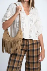 Blusa de color crudo con diseño oversize, confeccionada en una mezcla de viscosa y lino. Presenta detalles de encaje vertical en el frente y en las mangas, escote en V y mangas tres cuartos con terminación elástica.