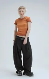 Remera de manga corta y cuello redondo, confeccionada en tejido ribb 100% algodón, de calce ajustado al cuerpo y largo a la cadera. El color es un marrón oscuro con efecto desgastado o teñido. Presenta costuras externas visibles en los hombros y laterales.