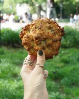 Anillo de diseño abierto con estructura de rejilla entrelazada, elaborado artesanalmente en metal con acabado plateado.