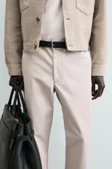 Pantalón chino de corte regular fit, confeccionado en tejido de algodón con elasticidad. Presenta bolsillos frontales, bolsillos traseros de vivo y cierre frontal con cremallera y botón.