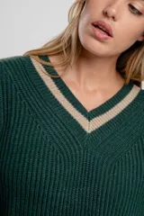 Sweater blanco de punto con cuello en V y ribetes grises en cuello, puños y bajo.