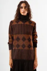 Sweater de cuello alto con diseño de tejido jacquard en tonos marrones y negros, con patrón geométrico y de rayas verticales, de manga larga con puños acanalados.