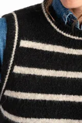 Chaleco de punto negro con rayas horizontales color crema, cuello alto y corte ajustado.