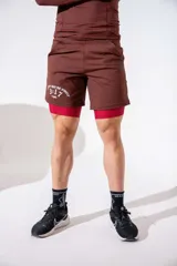 Short deportivo de lycra color marrón, con calza interna integrada en color rojo y estampado lateral en blanco.