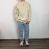 Buzo de corte oversize color beige, con estampa gráfica en la espalda que incluye botellas de vino y texto descriptivo.