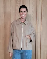 Chaqueta de textura bouclé en color bordó, con corte oversize, cuello camisero, cierre frontal y bolsillos laterales.