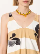 Musculosa con estampado a rayas horizontales color blanco y amarillo, con estampado de limones negros.
