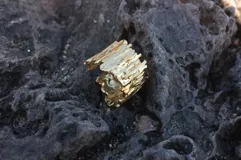 Anillo de diseño escultural y texturado, con acabado rugoso que simula una superficie montañosa o corteza.