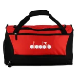 Bolso deportivo tipo duffel bag de la marca Diadora, bicolor rojo y negro. Presenta un compartimento principal con cierre y un bolsillo lateral de malla con cierre. Cuenta con asas de mano y una correa ajustable para llevar al hombro.