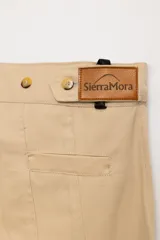 Bombacha de campo de gabardina color beige, de corte holgado con costuras verticales decorativas y botamangas negras abotonadas.