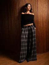 Pantalón tipo palazzo de corte amplio y tiro alto, con diseño de estampado a cuadros tipo tartán en tonos oscuros. Presenta pinzas en la cintura y bolsillos laterales.