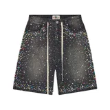 Short de jean negro con corte baggy, decorado con múltiples cristales y piedras de colores en toda la superficie. Presenta cordones largos en la cintura y diseño de cinco bolsillos.