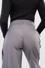 Pantalon de vestir gris con detalle de franjas laterales negras y etiqueta de marca Dolce en el bolsillo trasero.