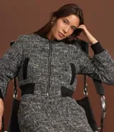 Campera bomber corta confeccionada en tweed con cuello alto, cierre frontal con cremallera, bolsillos y detalles en rib.