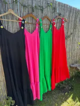 Vestido largo fucsia con breteles finos y detalle de tachas doradas en los breteles.