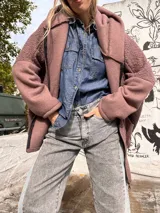 Campera con capucha de textura tipo corderito en color chocolate, con cierre frontal, bolsillos frontales aplicados y detalles en tela lisa en puños y bolsillos.