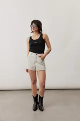Short gris claro de tiro alto con costuras pespunteadas en contraste y bolsillos traseros amplios. Presenta una etiqueta de cuero rojo en la parte posterior de la cintura.