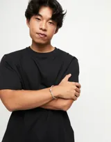 Pulsera semirígida plateada con detalle de cuero rosa y esfera plateada.