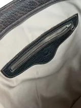 Bolso tipo shopper de cuero marrón chocolate, con doble asa de hombro, cierre superior y bolsillo frontal con cierre y tirador decorativo de cuero con estampa animal print.