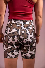 Calza biker deportiva con estampado abstracto en tonos marrones y blancos.