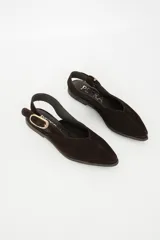 Sandalia chata color marrón con textura tejida, punta fina y tira trasera con hebilla dorada.