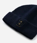 Gorro de lana tejido en canalé color azul marino, con doblez en el borde y detalle de letra B bordada en el frente en color naranja.