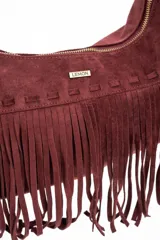 Cartera tipo bandolera de gamuza sintética color bordó, con diseño de flecos largos en la parte inferior y correa ajustable con nudo lateral. Incluye cierre superior y detalle de placa metálica con logo.