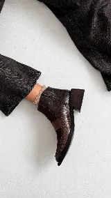 Botinetas de caña baja confeccionadas en una combinación de cuero napa y gamuza en tono bordó. Presentan un diseño de paneles con una banda central horizontal, puntera cuadrada y taco geométrico de color negro.