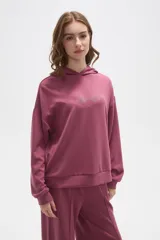 Canguro con capucha de calce holgado, color bordó, con detalle de aplique de strass en el pecho.