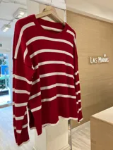 Sweater rojo con rayas horizontales blancas, de corte holgado y mangas largas.