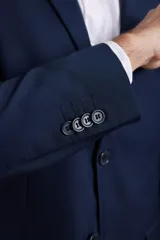 Traje de corte slim fit compuesto por saco de dos botones y pantalón de vestir a juego. Presenta una silueta moderna y entallada.