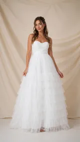 Vestido largo blanco de tul, estilo strapless con corsé drapeado en forma de corazón y falda amplia con múltiples volados.