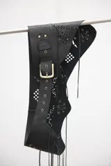 Faja ancha de cuero vacuno negro con diseño calado, hebilla metálica frontal y detalles de flecos en los extremos.