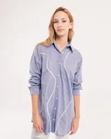Camisa celeste de algodón con corte oversized, botones frontales a tono y vivos blancos ondulados en el frente.